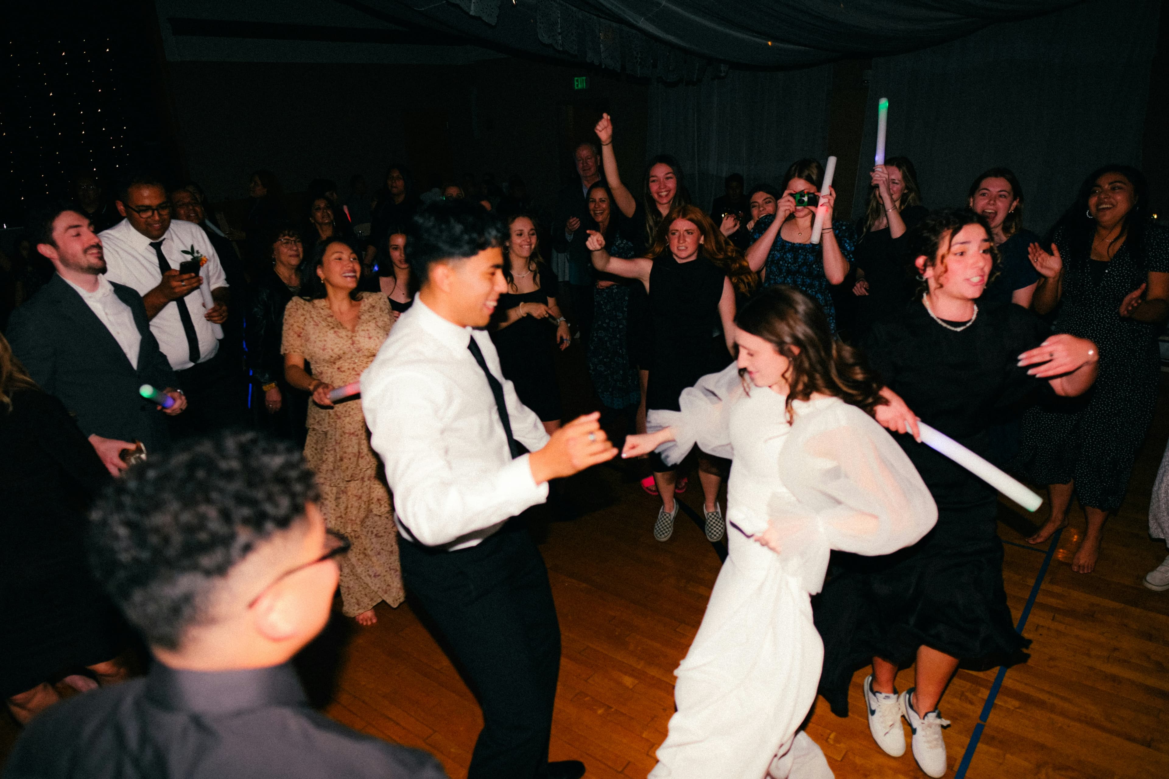 Brudepar danser med jublende gjester på dansegulvet